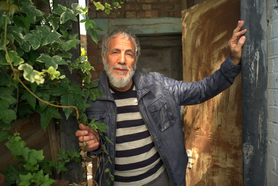 Yusuf Islam (Cat Stevens) leaning against a door.