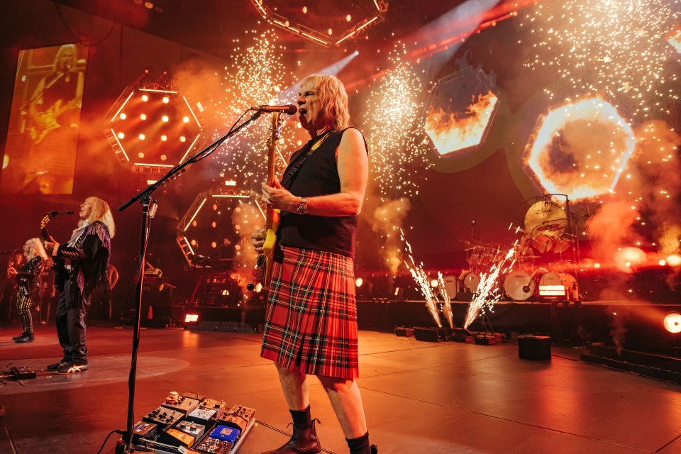 Christopher Guest performing onstage with fireworks.