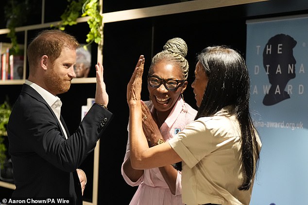 Prince Harry high fives Chief Workforce Innovation Officer Karen Pavlin in London today