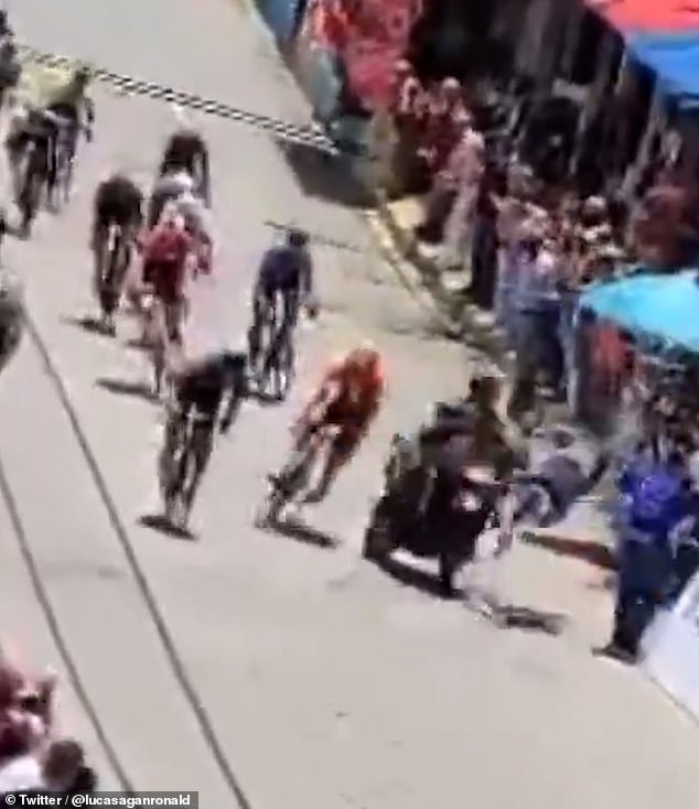 A police motorbike escorting the cyclists cut across the track, smashing into several bikers