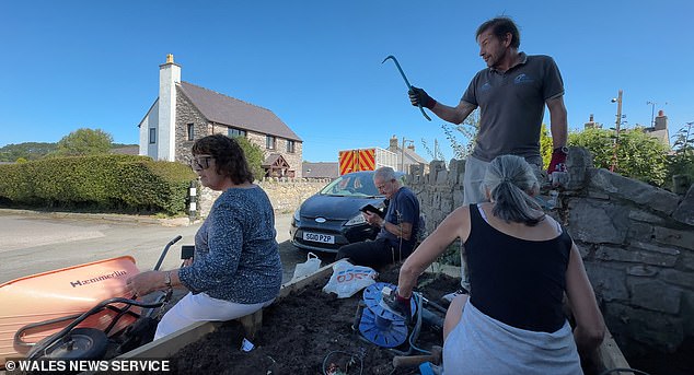 Community volunteers sat on the planter in an attempt to stop the couple from destroying it