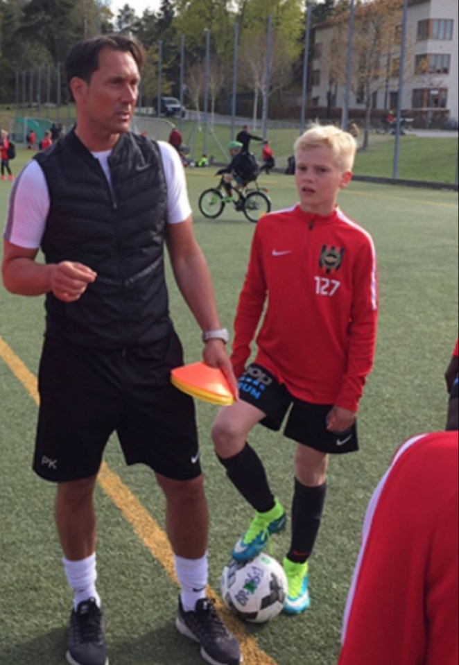 Soccer coach instructing a young player.