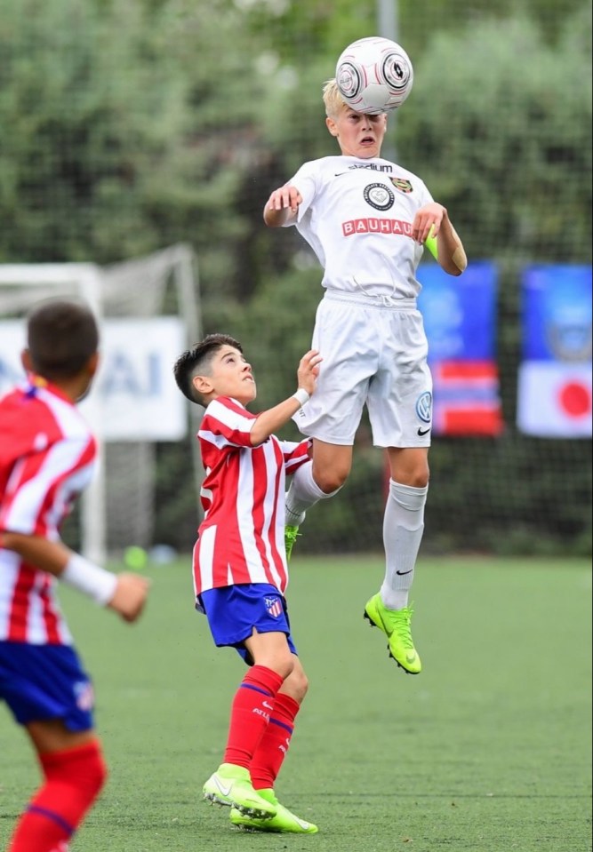 Youth soccer players heading a ball.