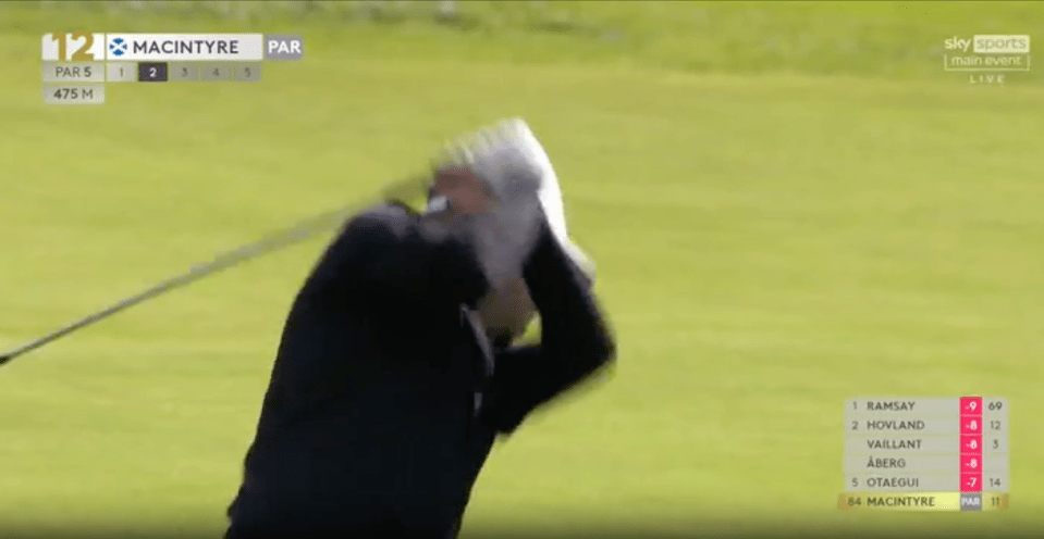 Golfer taking a swing during a golf tournament.
