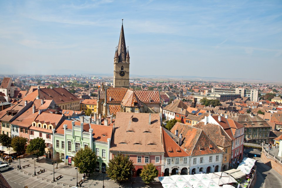 Aerial view of Sibiu, Romania, showing the city's rooftops and the Evangelical Cathedral tower.