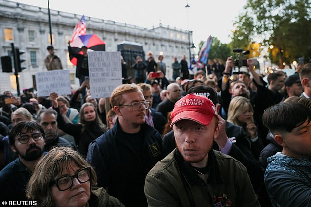 A man wears a hat with a message "Make England Great Again" as people attend a vigil near the Montgomery Statue in Whitehall