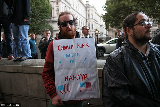 A man holds a sign as people attend a vigil near the Montgomery Statue in Whitehall, to commemorate U.S. conservative activist Charlie Kirk
