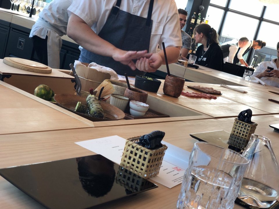 Chef preparing sushi at a restaurant counter.