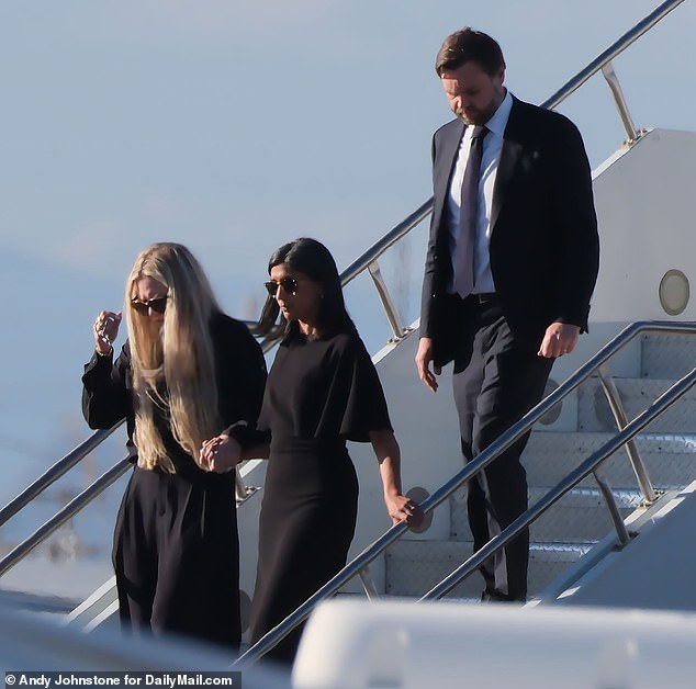 Erika held Usha Vance's hand as she arrived back in Arizona on Thursday. Dressed in all black and wearing sunglasses as they somberly walked off the aircraft with JD Vance trailing behind
