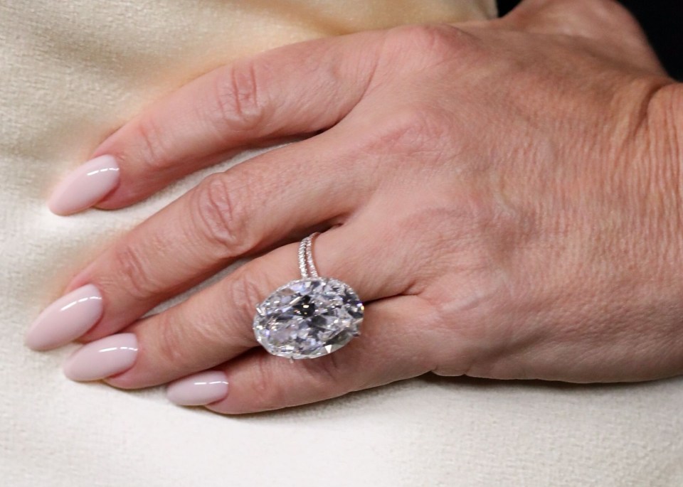 Close-up of Lauren Sánchez's hand wearing a large diamond ring.