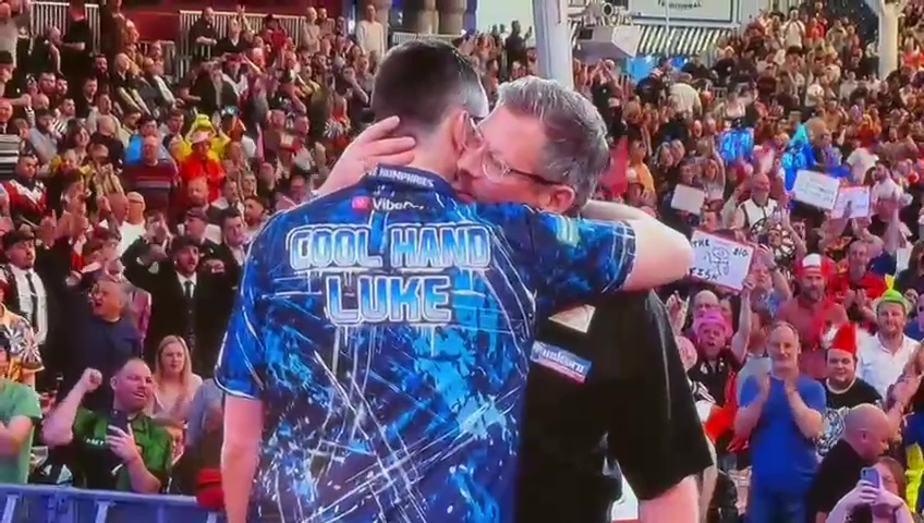 James Wade kissing Luke Humphries' neck during a darts match.