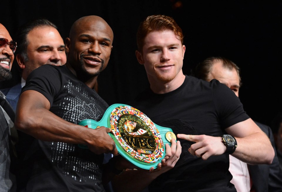 Floyd Mayweather Jr. and Canelo Alvarez holding a WBC super welterweight championship belt.