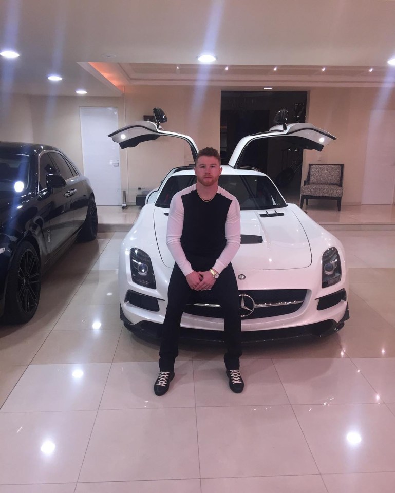 Saul Canelo Alvarez sitting in front of a white Mercedes-Benz SLS AMG.