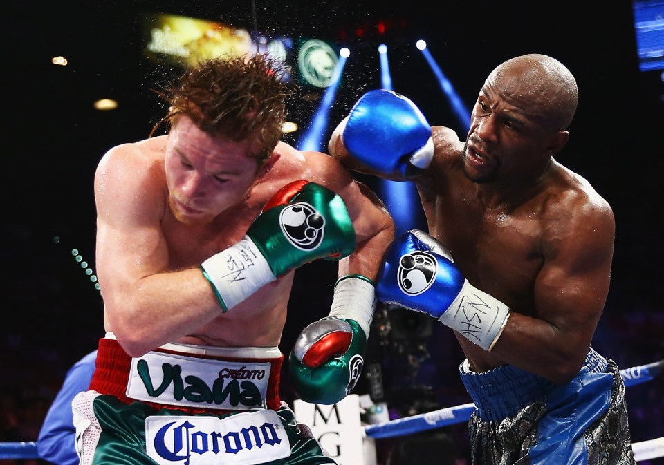 Floyd Mayweather Jr. throwing a punch at Canelo Alvarez during a boxing match.
