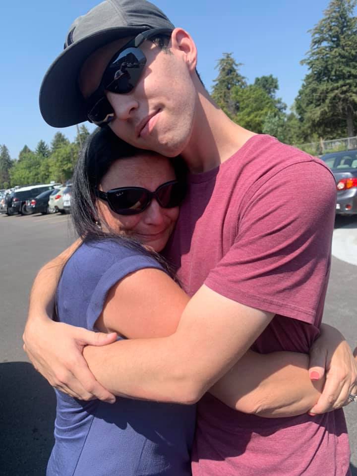 A mother and son embracing.