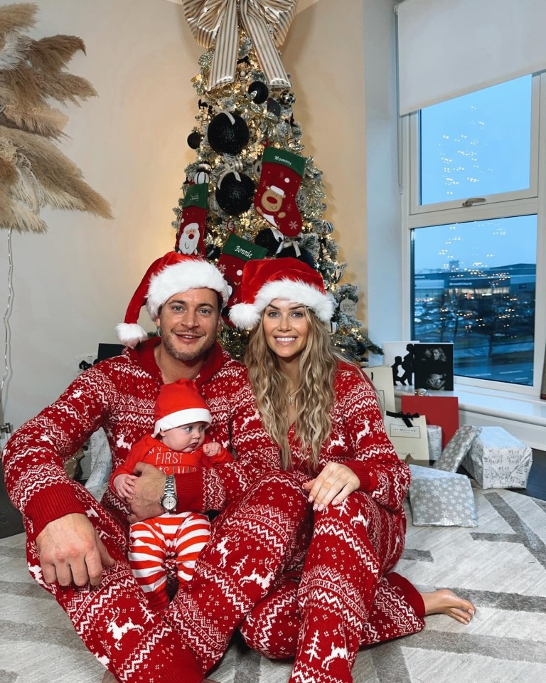 Family in matching Christmas pajamas by a decorated tree.