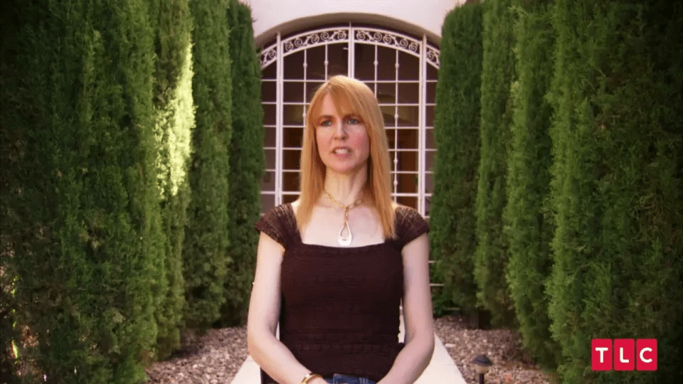Woman with long reddish-blonde hair speaking outdoors.