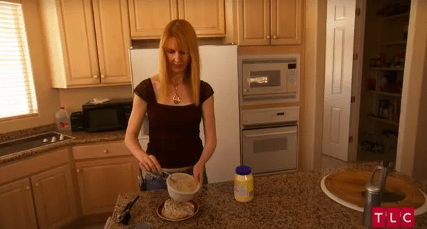 Woman mixing food in a bowl in a kitchen.