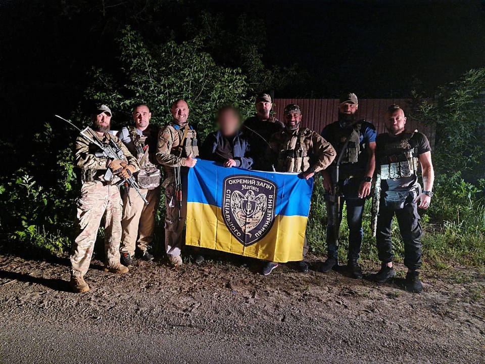 Ukrainian soldiers posing with a flag.