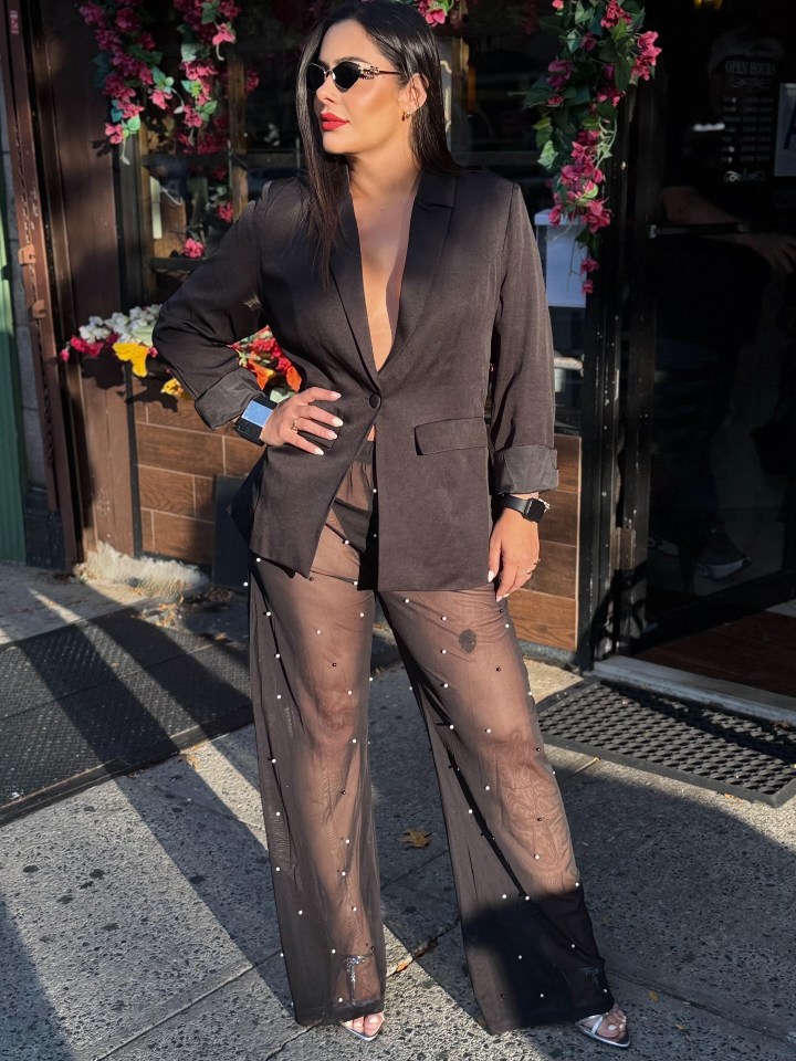 Woman in black blazer and sheer beaded pants.