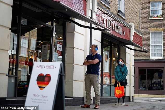 Pret¿s chief executive said the impact of social distancing had been 'severe' and has changed consumer habits. Pictured: Customers adhere to social distancing as they queue to enter a recently re-opened Pret-A-Manger