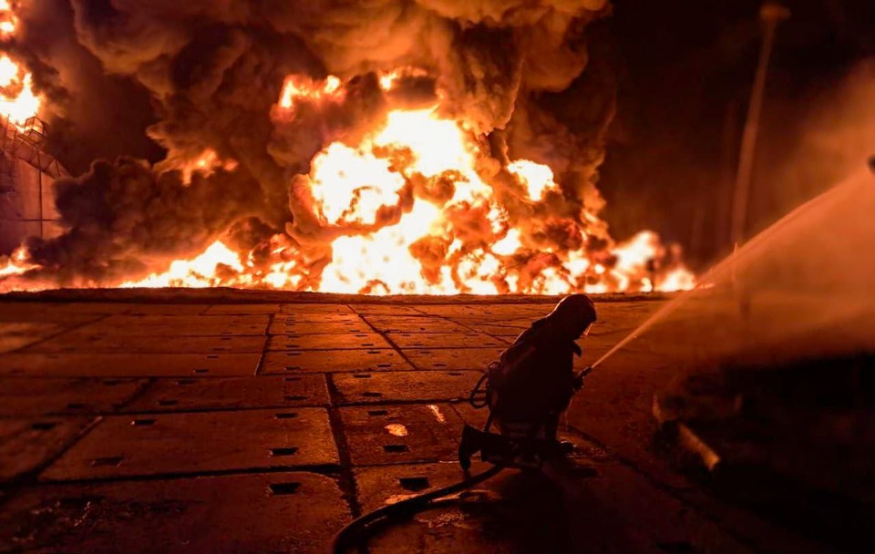 Ukrainian rescuer fighting a large fire at an infrastructure facility.