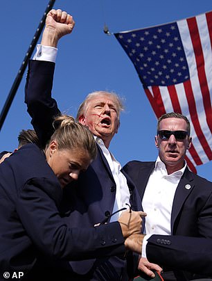 Donald Trump raises a fist to the crowd after being shot at the rally in Pennsylvania