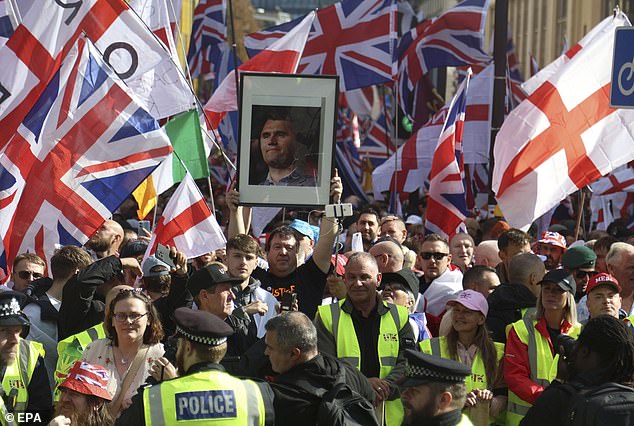 A man holds a photograph of Charlie Kirk, a conservative influencer who was shot dead in the US this week, during the Unite The Kingdom march