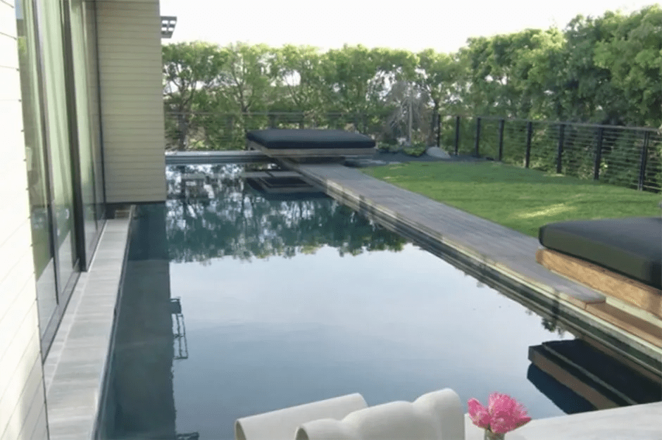 Modern pool with floating deck and lounge chairs.