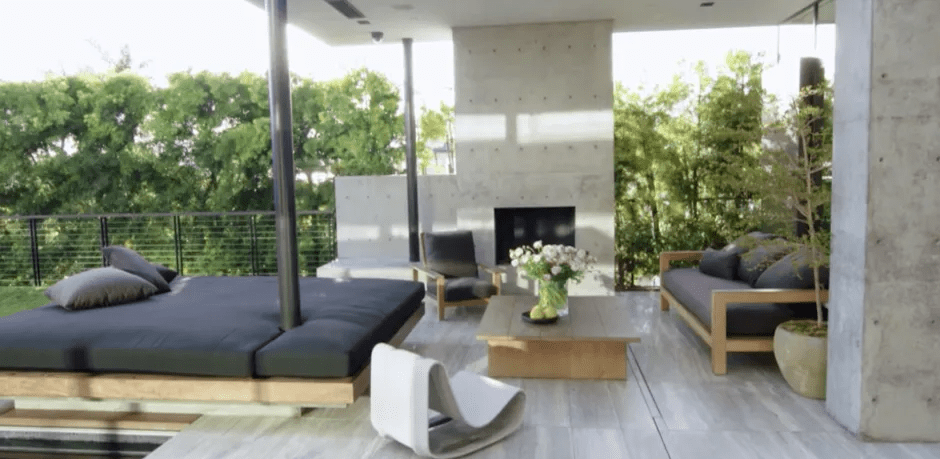 Modern outdoor patio with seating area and fireplace.
