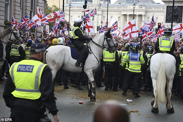 Protesters taking part in the 'Unite the Kingdom' rally are held back by police officers in central London