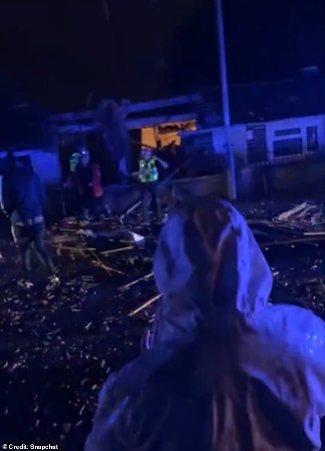 Neighbours gathered outside the property in shock, picking their way through rubble strewn across the street