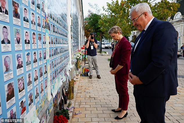 Ukrainian Foreign Minister Andrii Sybiha and British Foreign Secretary Yvette Cooper bow as they visit the Wall of Remembrance of the Fallen for Ukraine, outside St. Michael's Cathedral, amid Russia's attack on Ukraine, in Kyiv, Ukraine, September 12, 2025