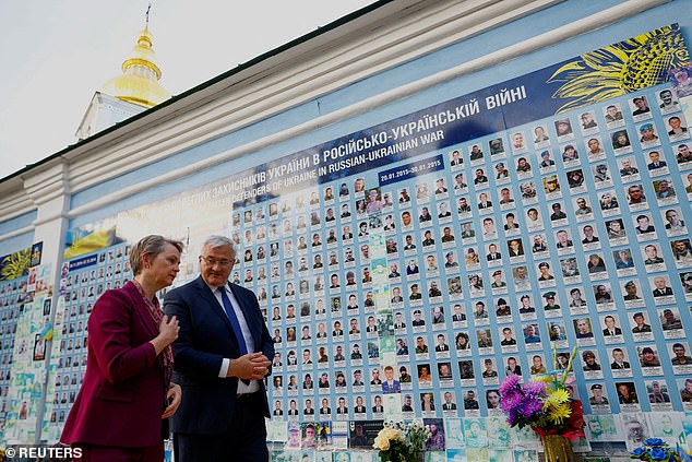 Ukrainian Foreign Minister Andrii Sybiha and British Foreign Secretary Yvette Cooper speak as they visit the Wall of Remembrance of the Fallen for Ukraine, outside St. Michael's Cathedral, amid Russia's attack on Ukraine, in Kyiv, Ukraine