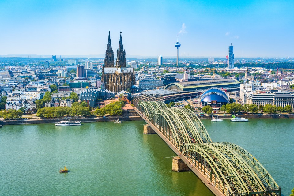 Aerial view of Cologne Cathedral, Hohenzollern Bridge, and the Rhine River in Cologne, Germany.