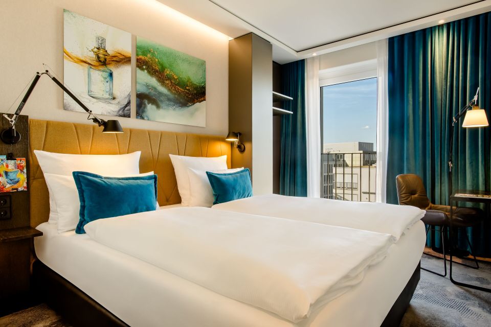 Hotel room with two beds and city view.
