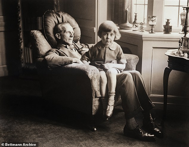A.A Milne sits with his no less famous son Christopher Robin at their home in East Sussex