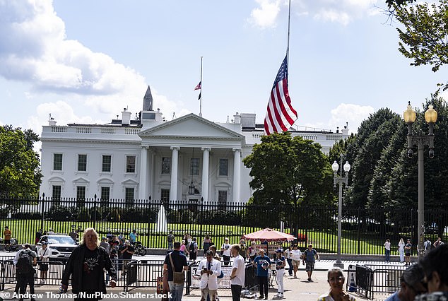 The view outside the White House shows people looking at the flag at half-staff for Charlie Kirk on Thursday