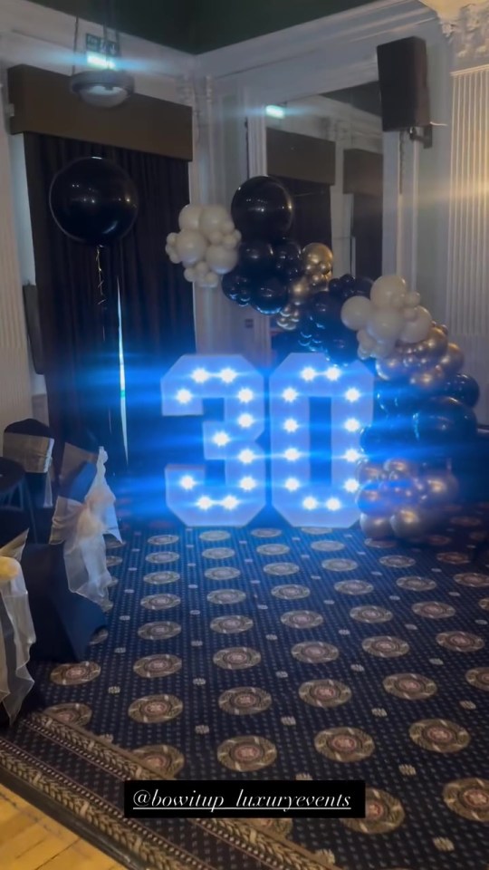 Lit "30" sign with balloon arch for a 30th birthday party.