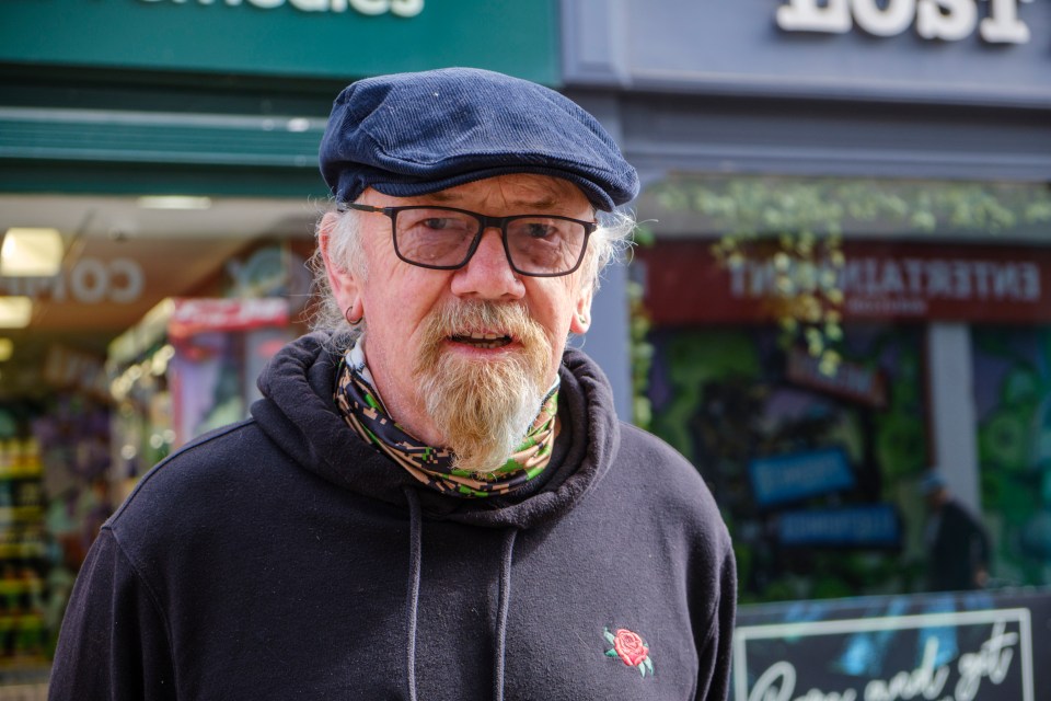 Portrait of a man wearing glasses and a flat cap.