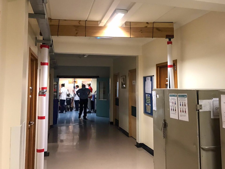 Temporary supports holding up the ceiling of a hospital corridor.