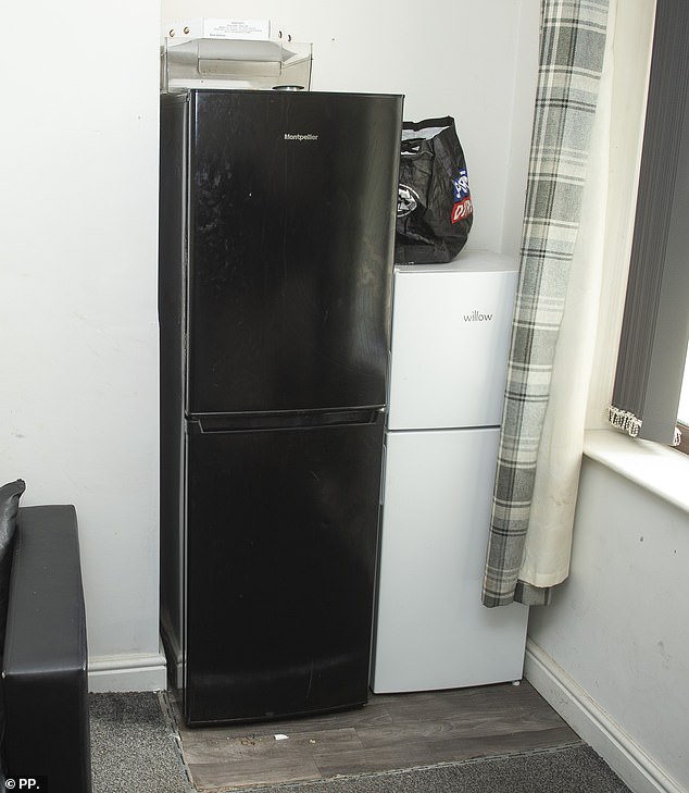 Interiors of Dere's HMO in Burnley show two large fridges next to his living room sofa