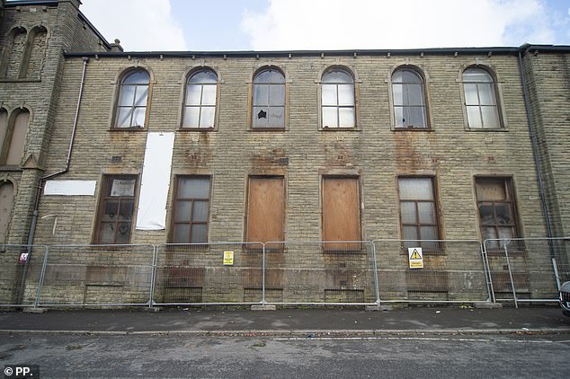 Lancashire Police said they were investigating the damage to the property (above) which has been left charred and with its windows boarded up