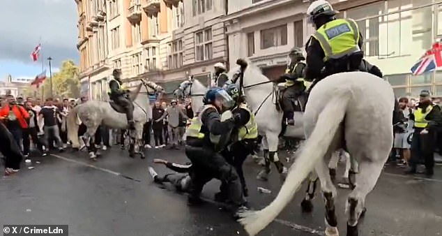 The man - who appeared to be unconscious - was dragged away to safety by police