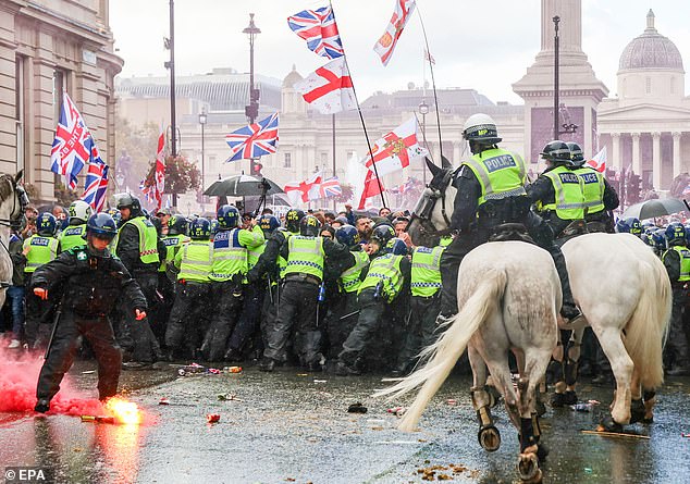Flares are thrown as protesters taking part in a 'Unite the Kingdom' rally are held back by police officers