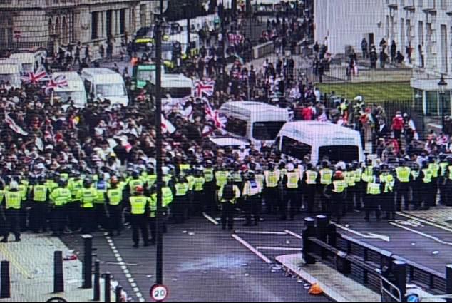 Police officers hold the line between Unite The Kingdom protesters and the 'serile zone' which separates them from counter-protesters