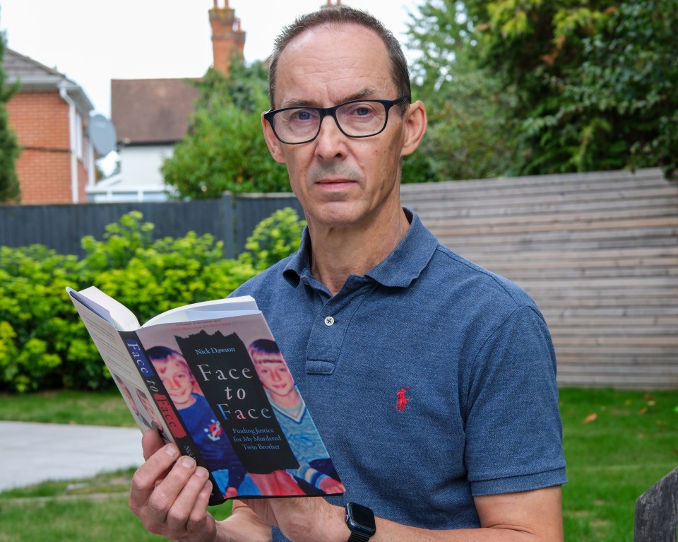 Man holding a book titled "Face to Face: Finding Justice for My Murdered Twin Brother".