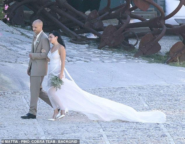The pop star, 32, displayed her edgy sense of style in a grecian-inspired bridal look as she and The 1975 drummer, 35, shared their vows, two months after their London nuptials