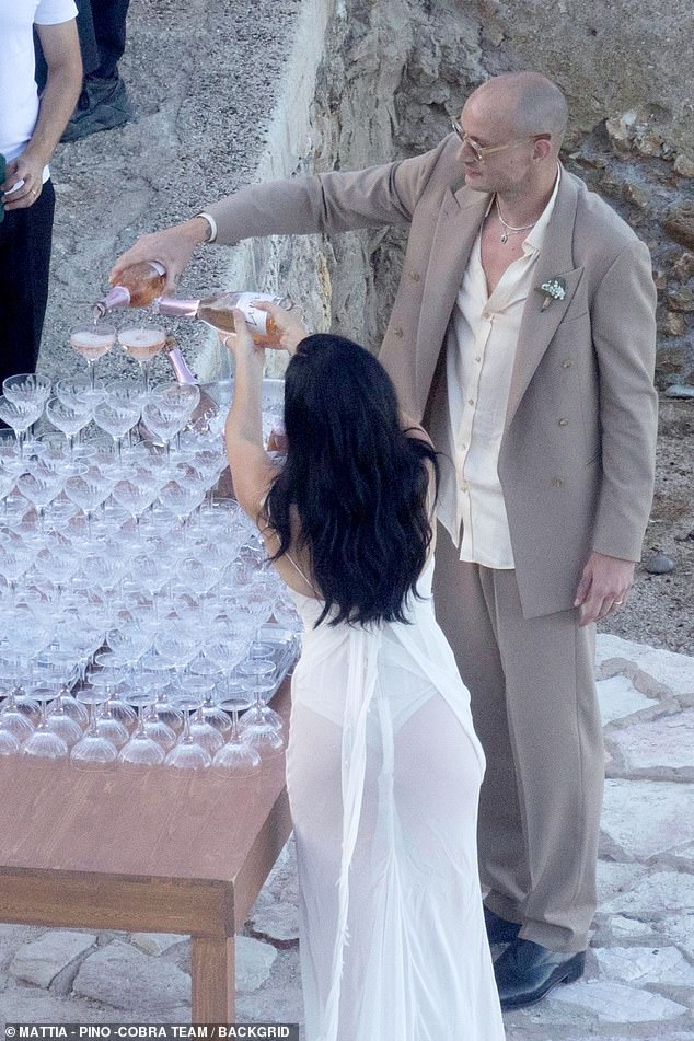 Popping bottles of fizz, the pair poured out a champagne tower for the guests to enjoy, unable to resist another smooch