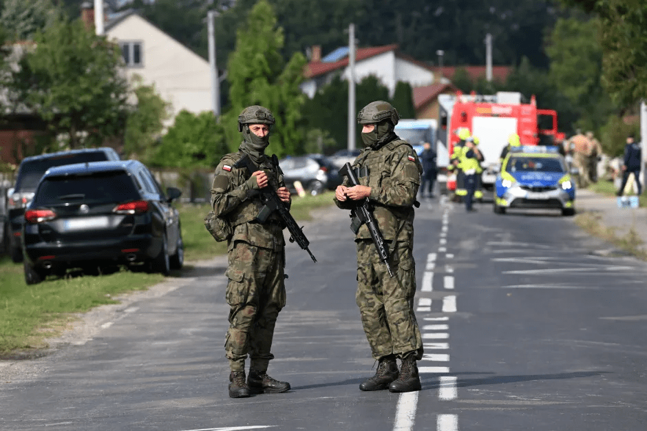 Two armed soldiers standing on a road.